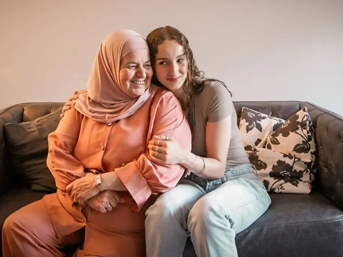 Deux protagonistes sur le divan qui se font un calin