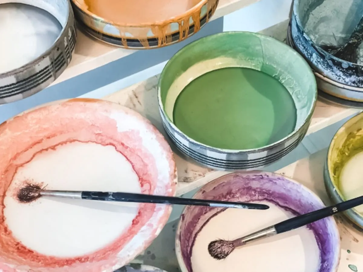 Pinceaux et pots de peintures de différentes couleurs.