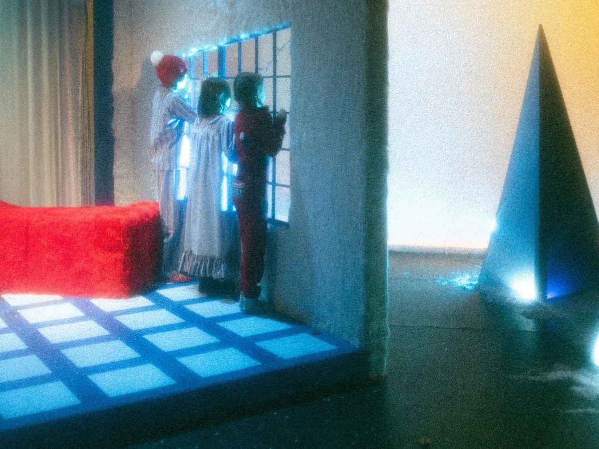 Trois enfant en pyjama regardent par la fenêtre dans une scène du spectacle Conte d'hiver du Ballet Opéra Pantomime.