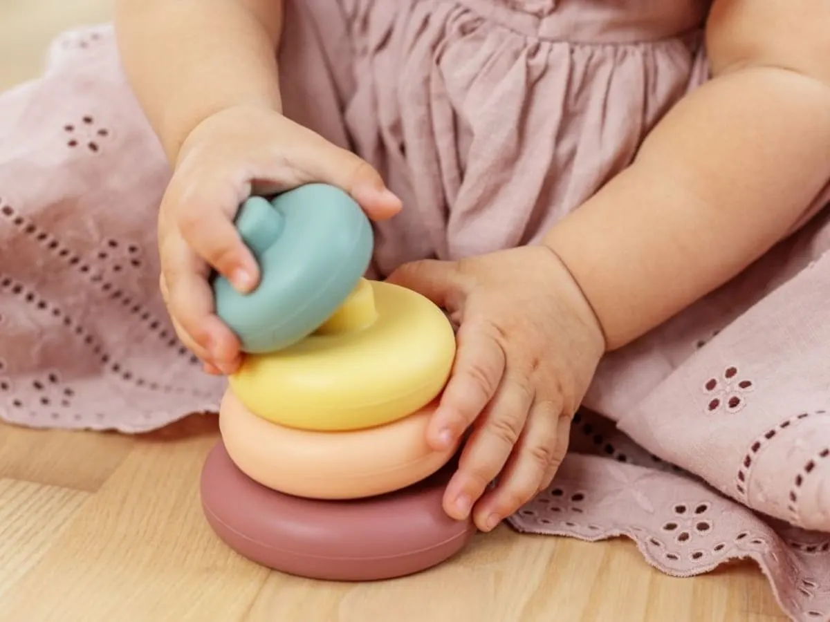 Photo d'un enfant assis par terre jouant avec des petites anneaux