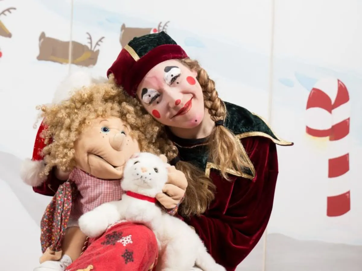 Lutin du père Noël qui tient une marionnette