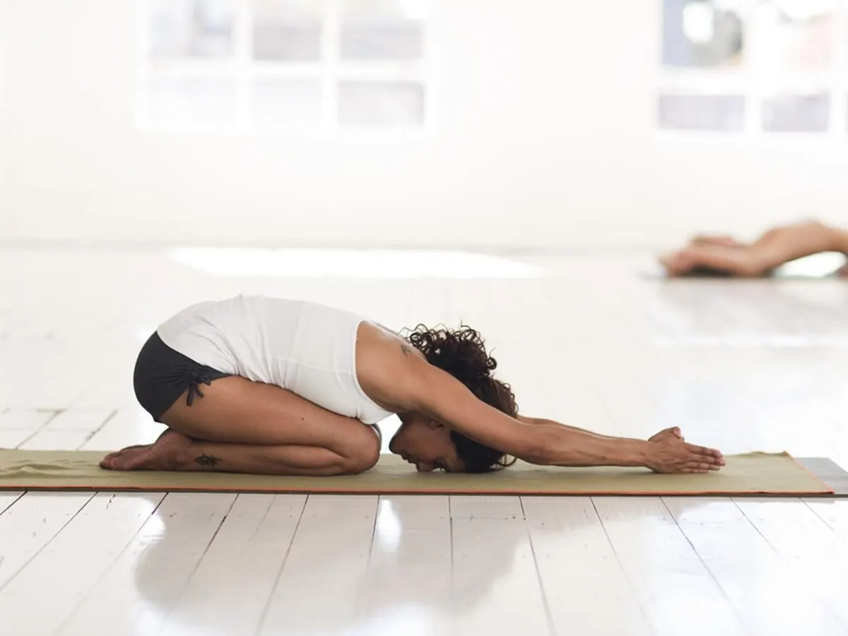 Une personne dans la posture de l'enfant en yoga.