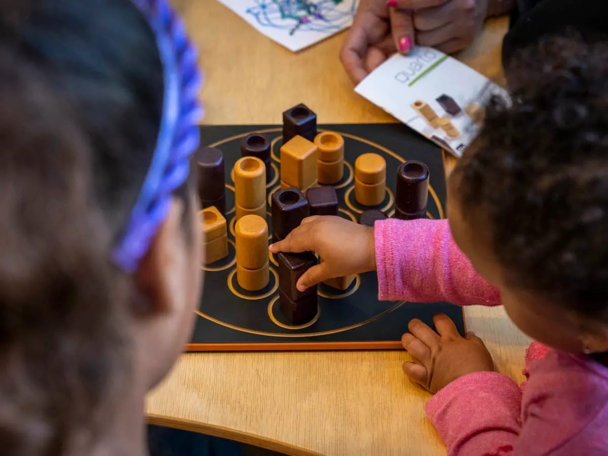 Deux filles jouant à un jeu de société à la bibliothèque Frontenac.