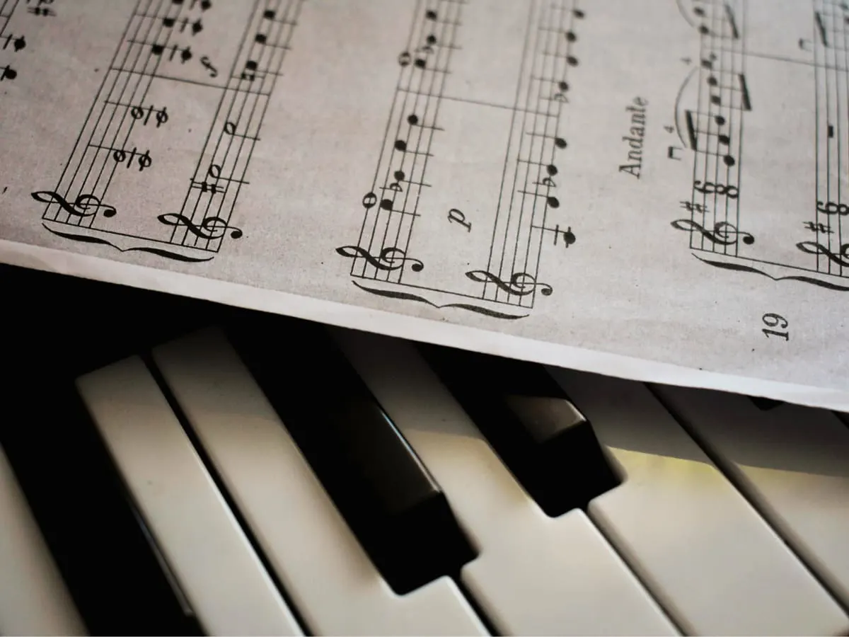 Une partition de musique imprimée est déposée sur un clavier de pianoe.