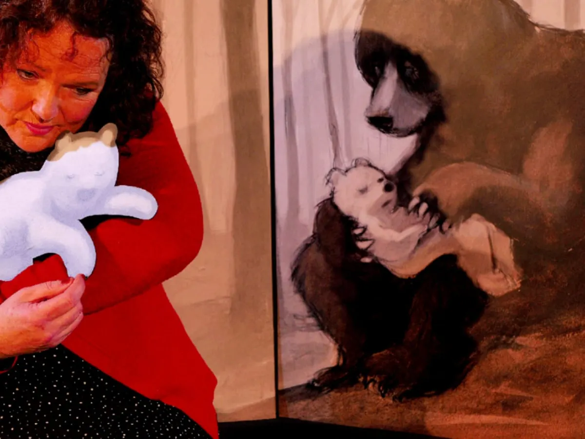 Une femme tient dans ses bras petit ours blanc en carton.
