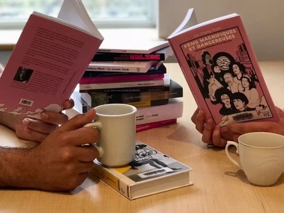 Gros plan sur les mains de deux personnes qui lisent un livre.