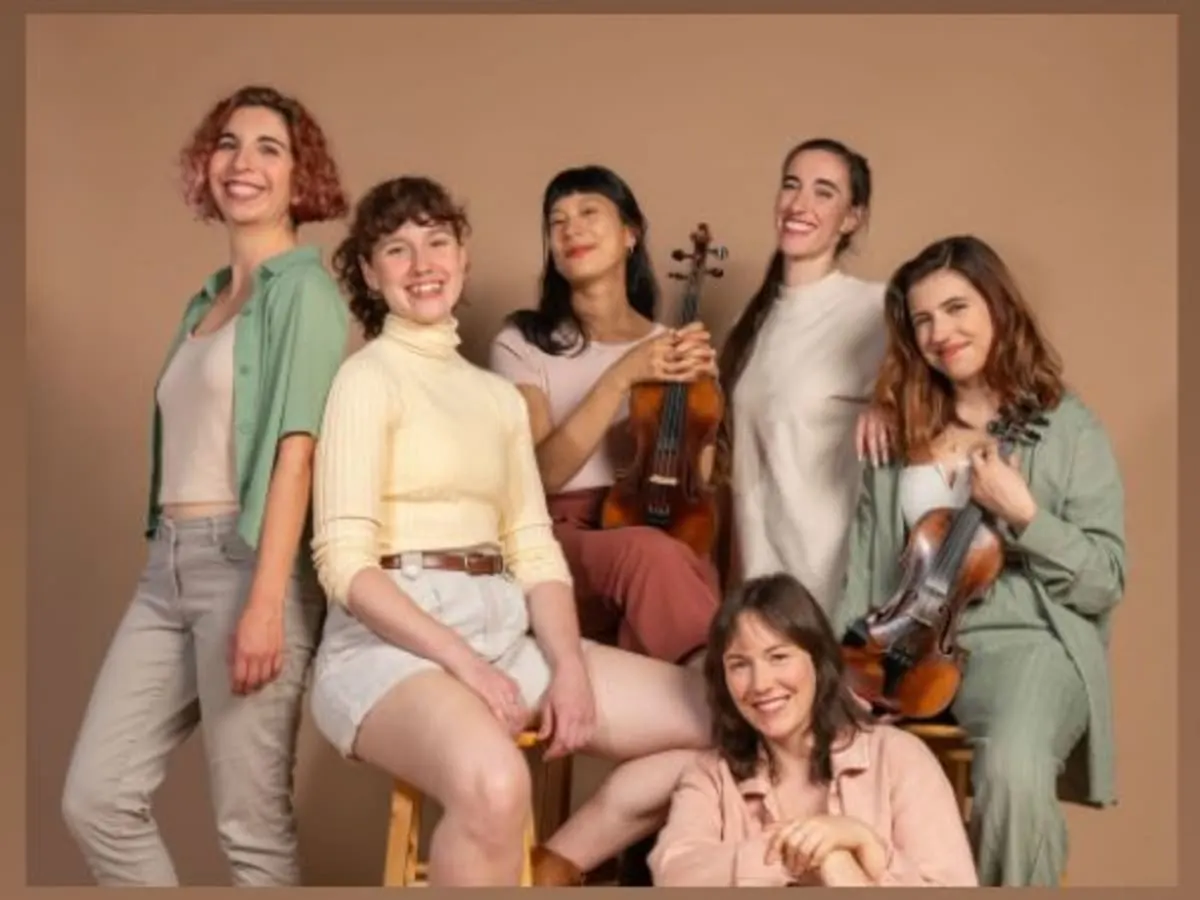 Les cinq musiciennes souriantes avec leurs instruments