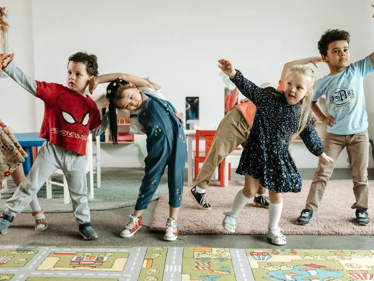 Vue de face d’une rangée d’enfants faisant des étirements.